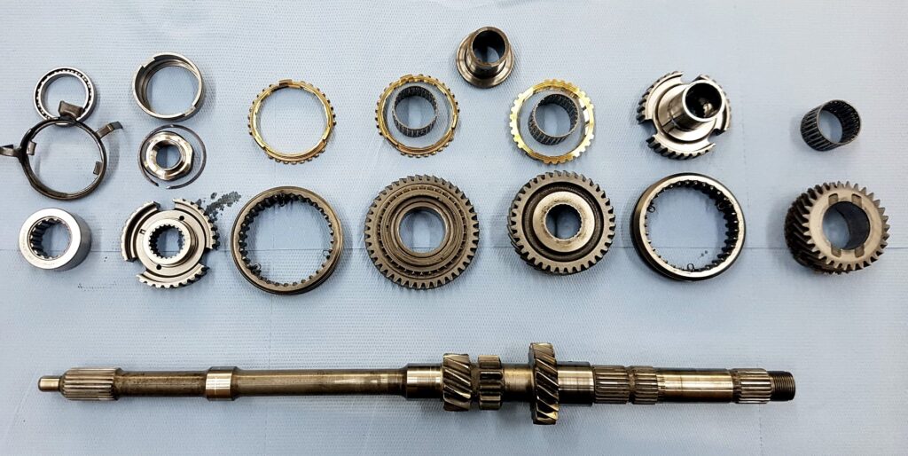 Zerlegte Getriebekomponenten mit Zahnrädern, Synchronringen und Welle bei einer Revision