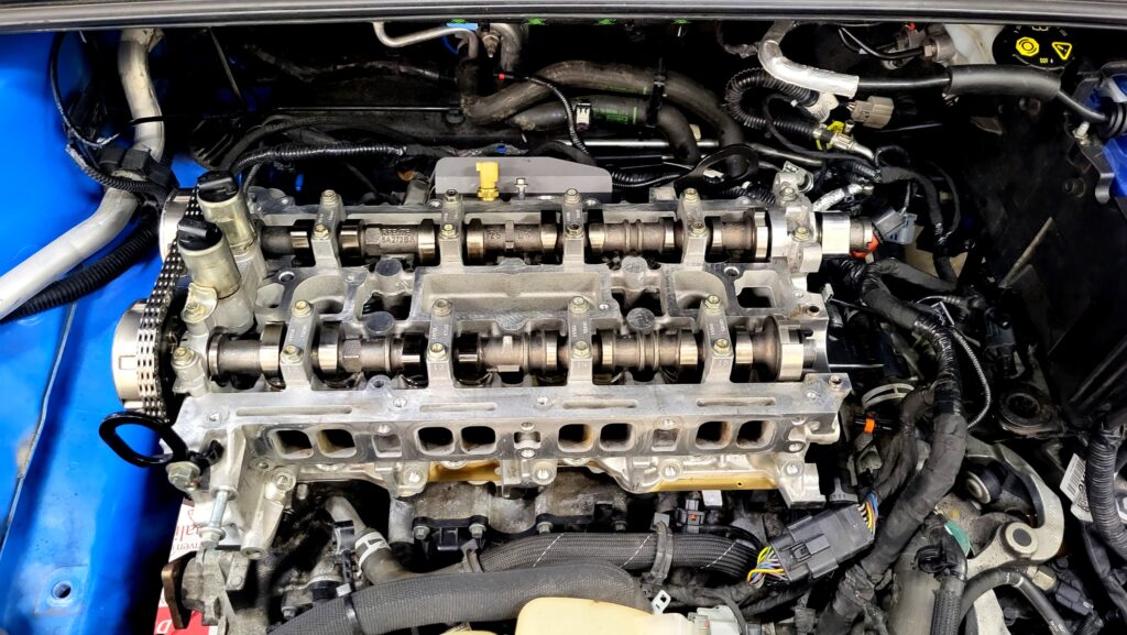 Ford Focus RS MK3 Zylinderkopfdichtung während der Reparatur – offener Zylinderkopf mit sichtbarer Nockenwelle in Frontansicht.