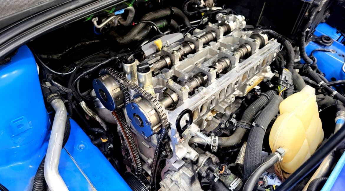 Ford Focus RS MK3 Zylinderkopfdichtung im Reparaturprozess – Seitenansicht des Zylinderkopfs mit sichtbarem Steuertrieb.